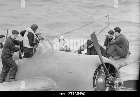 Fleet Air Arm serie, a bordo HMS vittoriosa. Settembre 1942. Un pilota di entrare in un aeromobile. Foto Stock