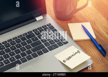 14 ottobre 2023: Scrivania con tazza e computer portatile con nota: FOTOMONTAGGIO e-Learning *** Schreibtisch mit Tasse und laptop computer mit Notiz: E-Learning FOTOMONTAGE Credit: Imago/Alamy Live News Foto Stock