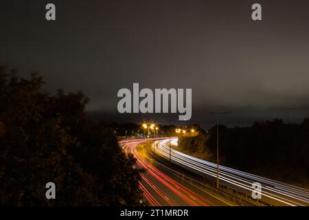 Traffico in rapido movimento su percorsi a semaforo notturno A1(M) Foto Stock