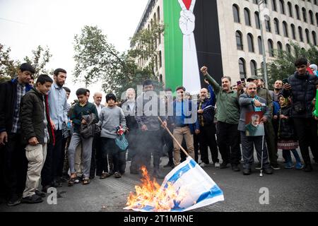 Teheran, Iran. 13 ottobre 2023. I fedeli iraniani bruciano una rappresentazione della bandiera israeliana durante il loro raduno pro-palestinese prima delle preghiere del venerdì. (Foto di Sobhan Farajvan/Pacific Press/Sipa USA) credito: SIPA USA/Alamy Live News Foto Stock