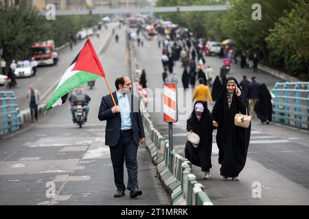 Teheran, Iran. 13 ottobre 2023. Un adoratore iraniano detiene una bandiera palestinese e partecipa con la sua famiglia a un raduno pro-palestinese prima della preghiera del venerdì. (Foto di Sobhan Farajvan/Pacific Press/Sipa USA) credito: SIPA USA/Alamy Live News Foto Stock