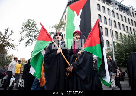 Teheran, Iran. 13 ottobre 2023. Due adoratori iraniani detengono bandiere palestinesi durante un raduno pro-palestinese prima delle preghiere del venerdì. (Foto di Sobhan Farajvan/Pacific Press/Sipa USA) credito: SIPA USA/Alamy Live News Foto Stock