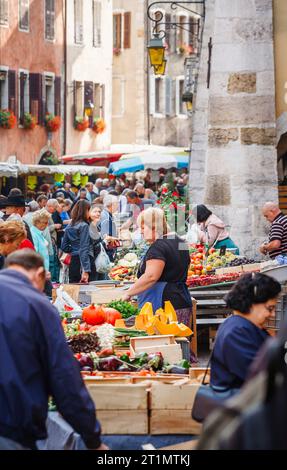 Bancarelle presso l'affollato mercato alimentare locale all'aperto lungo la strada nella città vecchia, Annecy, Francia Foto Stock