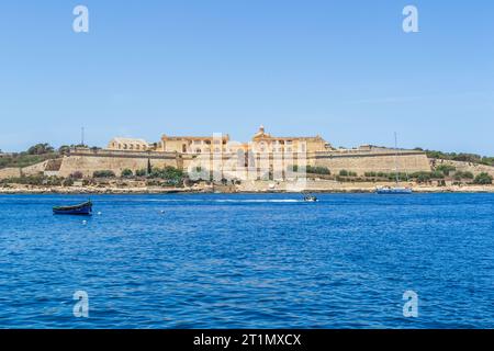 Gzira, Malta - 6 giugno 2016: Luzzu e moto d'acqua nel porto di Marsamxett di fronte a Fort Manoel sull'isola di Manoel. Foto Stock