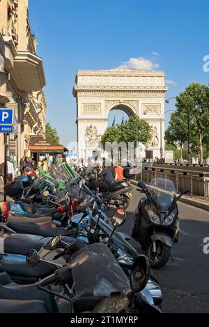 Parigi, Francia — luglio 2028: Le motociclette costeggiano il marciapiede su Avenue de la grande Armée prima dell'Arc de Triomphe de l'Étoile Foto Stock