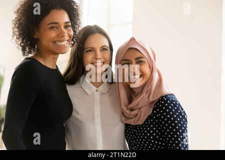 Felice giovane donna professionista musulmana in piedi vicino a colleghi femminili Foto Stock