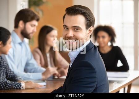 Giovane uomo d'affari allegro e di successo in posa per la telecamera Foto Stock