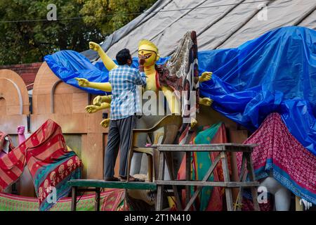 Nuova Delhi, India. 14 ottobre 2023. Un artista ha visto dare tocchi finali all'idolo di argilla della Dea Durga per l'imminente festival Durga Puja, al tempio Sarojini Nagar Kalibari. Durga Puja è un festival indù celebrato principalmente nel Bengala Occidentale e dalle comunità bengalesi di tutto il mondo. Si tratta di una celebrazione di più giorni dedicata alla dea Durga, che simboleggia il potere femminile divino e la vittoria del bene sul male. (Immagine di credito: © Pradeep Gaur/SOPA Images via ZUMA Press Wire) SOLO PER USO EDITORIALE! Non per USO commerciale! Foto Stock