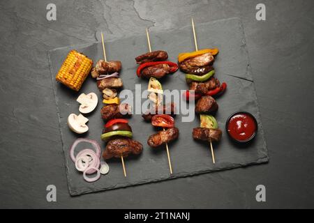 Deliziose shish kebab servite su un tavolo grigio testurizzato, vista dall'alto Foto Stock