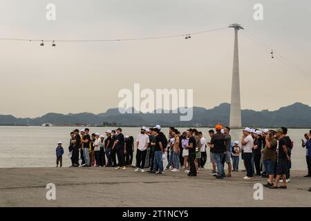 Passeggeri in attesa di salire a bordo del traghetto dal porto di Haiphong all'isola di Cat Ba. Cap Treo Cable Gondola, che collega Cat Ba Island a Haiphong, ha Long Bay, Vietn Foto Stock
