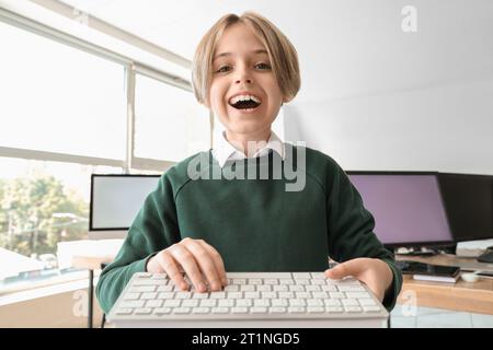 Bambino con la tastiera nel laboratorio informatico della scuola Foto Stock