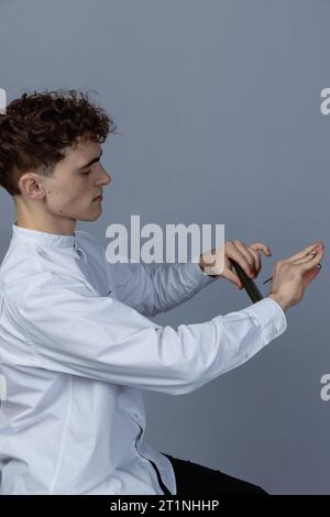 Bellissimi uomini in studio di ritratti. Il barbiere tiene un pettine in mano. Foto Stock