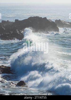 Una linea di onde che si schiantano vicino alla riva Foto Stock