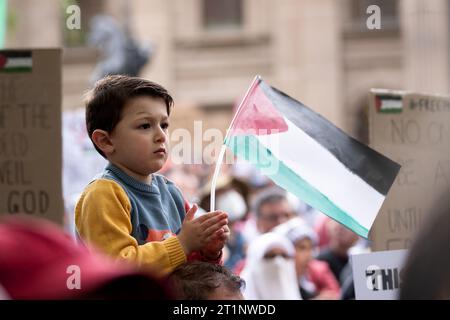 Melbourne, Australia, 15 ottobre 2023. Un bambino piccolo è visto tenere una bandiera palestinese durante il raduno pro-Palestina presso la Biblioteca di Stato della Biblioteca di Stato il 15 ottobre 2023 a Melbourne, in Australia. Crediti: Dave Hewison/Speed Media/Alamy Live News Foto Stock