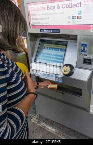 Donna che raccoglie i biglietti ferroviari da una biglietteria della Southeastern Railway fuori dalla stazione di Shortlands nel sud di Londra. Foto Stock