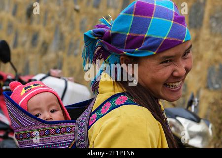 CAN Cau Market Scene, Vietnam. Giovane Hmong madre e bambino. Provincia di Lao Cai. Foto Stock