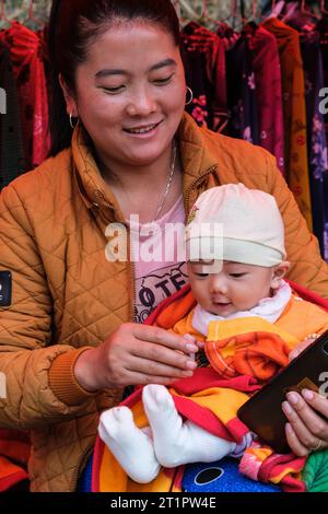 CAN Cau Market Scene, Vietnam. Hmong madre e bambino. Provincia di Lao Cai. Foto Stock