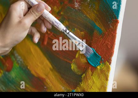 L'artista esegue tratti di pennello su tela, primo piano Foto Stock