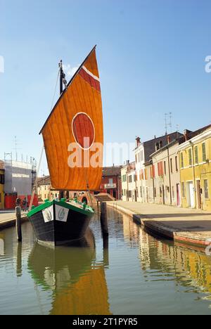 La Comacina è una storica imbarcazione a vela tipica della città di Comacchio, Emilia Romagna, Italia. La terza vela, così chiamata perché il punto in cui l'antenna è fissata all'albero è di circa un terzo della sua lunghezza, è tipica delle imbarcazioni del Mare Adriatico. Questo tipo di vela rappresenta la transizione più naturale dalle più antiche vele quadrate in latteo alle vele assiali tipiche delle moderne barche a vela. Le più antiche testimonianze relative all'uso di questo tipo di vela risalgono al XVII secolo. Foto Stock