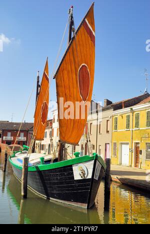 La Comacina è una storica imbarcazione a vela tipica della città di Comacchio, Emilia Romagna, Italia. La terza vela, così chiamata perché il punto in cui l'antenna è fissata all'albero è di circa un terzo della sua lunghezza, è tipica delle imbarcazioni del Mare Adriatico. Questo tipo di vela rappresenta la transizione più naturale dalle più antiche vele quadrate in latteo alle vele assiali tipiche delle moderne barche a vela. Le più antiche testimonianze relative all'uso di questo tipo di vela risalgono al XVII secolo. Foto Stock