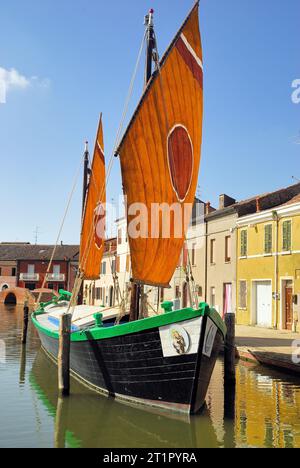 La Comacina è una storica imbarcazione a vela tipica della città di Comacchio, Emilia Romagna, Italia. La terza vela, così chiamata perché il punto in cui l'antenna è fissata all'albero è di circa un terzo della sua lunghezza, è tipica delle imbarcazioni del Mare Adriatico. Questo tipo di vela rappresenta la transizione più naturale dalle più antiche vele quadrate in latteo alle vele assiali tipiche delle moderne barche a vela. Le più antiche testimonianze relative all'uso di questo tipo di vela risalgono al XVII secolo. Foto Stock