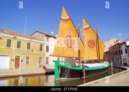 La Comacina è una storica imbarcazione a vela tipica della città di Comacchio, Emilia Romagna, Italia. La terza vela, così chiamata perché il punto in cui l'antenna è fissata all'albero è di circa un terzo della sua lunghezza, è tipica delle imbarcazioni del Mare Adriatico. Questo tipo di vela rappresenta la transizione più naturale dalle più antiche vele quadrate in latteo alle vele assiali tipiche delle moderne barche a vela. Le più antiche testimonianze relative all'uso di questo tipo di vela risalgono al XVII secolo. Foto Stock