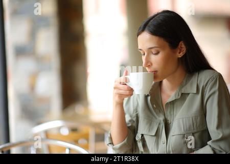 Donna in una terrazza bar che beve caffè Foto Stock