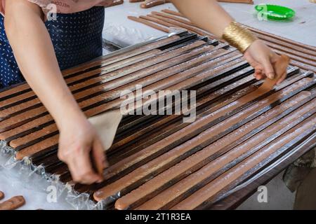 Fabbrica di caramelle al cocco, Vietnam, tra ho chi Minh e CAN Tho. Stendere le strisce da asciugare prima del taglio. Foto Stock