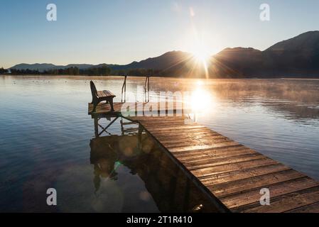 Alba su un molo di legno sulla riva del lago Kochel nelle prealpi in autunno, Baviera, Germania Foto Stock