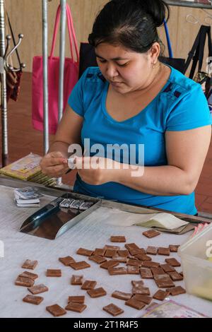 Mekong River, Vietnam. Donna che avvolge caramelle nella fabbrica di caramelle al cocco. Foto Stock