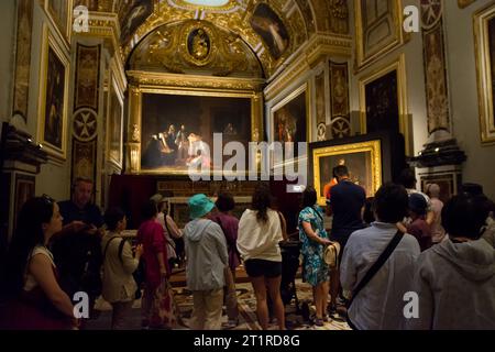 La Valletta, Malta - 17 giugno 2023: Turisti nella sala della sagrestia all'interno della co-cattedrale di la Valletta a Malta dove sono esibiti i due dipinti di Caravaggio Foto Stock