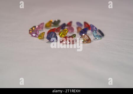 Pietre preziose a forma di cuore in vari colori sono disposte in un cerchio. I minerali di pietra naturale tagliati e lucidati sono preziosi e preziosi. Foto Stock