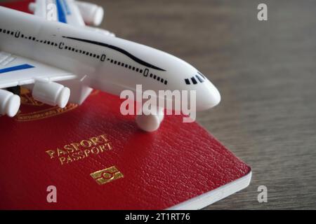 Immagine ravvicinata dell'aereo giocattolo e del passaporto. Concetto di viaggio e vacanza Foto Stock