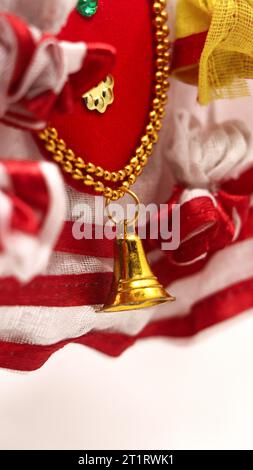 primo piano della decorazione natalizia con campana dorata e tessuto a righe rosse e bianche per festeggiare Foto Stock