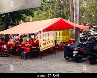 Giacarta, Indonesia - 15 ottobre 2023: Bancarelle di porridge di pollo lungo la strada aperto ogni pomeriggio fino a tarda notte a Taman Palem Lestari, Giacarta, Indon Foto Stock