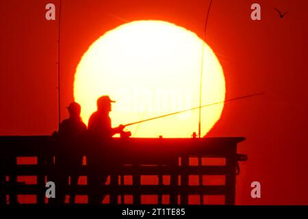 Isola di Palms, Stati Uniti. 15 ottobre 2023. Fisher folk, sagomato dall'alba, è pronto per la mattina a prendere il Sea Cabins Pier in una mattinata fredda nel basso paese, il 15 ottobre 2023 a Isle of Palms, South Carolina. Crediti: Richard Ellis/Richard Ellis/Alamy Live News Foto Stock