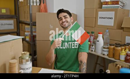 Giovane ispanico volontario sorridente e sicuro di avere la bandiera italiana al centro di beneficenza Foto Stock