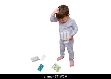 Il bambino ha aperto il cassetto con pillole e medicine, isolato su sfondo bianco. Bambino che tiene in mano un pacchetto di pillole in casa Foto Stock