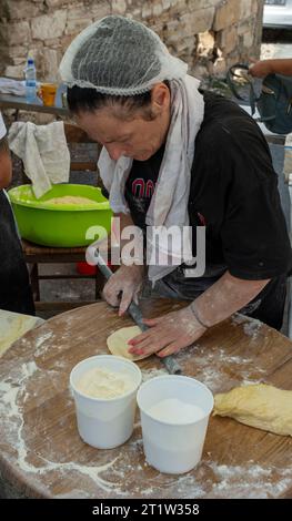 Una donna che prepara il pane Pitta all'Amargeti Olive Festival, Repubblica di Cipro. Foto Stock