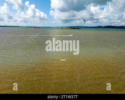 GETSKAR, SVEZIA - 30 LUGLIO 2023: Kite surfer che vola sull'acqua presso il punto di osservazione di Getskar sulla costa occidentale della Svezia. Foto Stock