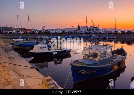 sozopol, bulgaria - 3 settembre 2019: piccole imbarcazioni da pesca nel porto al tramonto. cielo senza nuvole che si riflette nell'acqua Foto Stock