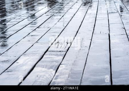 tavole bagnate di un marciapiede di legno durante la pioggia Foto Stock