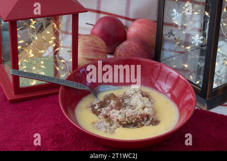 Abbondante budino invernale di mela e rabarbaro in ciotola con crema pasticcera Foto Stock