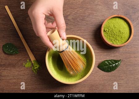 Donna che prepara il tè matcha al tavolo di legno, vista dall'alto Foto Stock