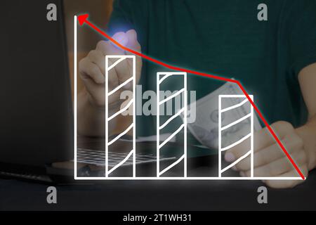 La mano di una donna preme una freccia virtuale su un grafico con un istogramma mentre lavora su un notebook al tavolo e tiene i dollari nella seconda mano, busine Foto Stock