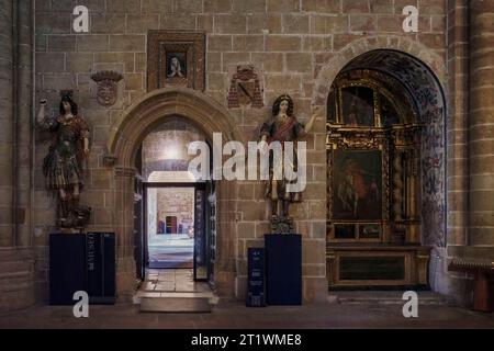 Ingresso al chiostro attraverso la porta di San Valero e la pala d'altare, nicchia di San Martín, cattedrale di Santa Maria, città di Sigüenza, Guadalajara. Foto Stock