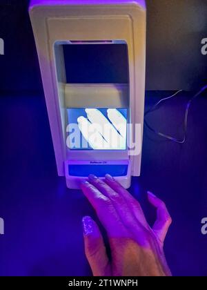 Lampada ultravioletta per controllare la validità del denaro in banca Foto Stock