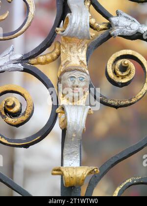 Testa in miniatura in una griglia barocca in ferro battuto nel monastero di Schöntal Foto Stock