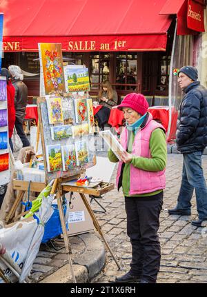 Pittore ed esposizione delle opere dell'artista di dipinti colorati di fiori in vendita, Place du Tertre, Montmartre, XVIII arrondissement, Parigi, Francia Foto Stock
