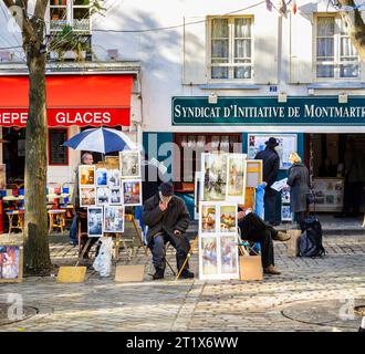 Venditore seduto che vende opere d'arte, dipinti ed espone immagini in vendita a Place du Tertre, Montmartre, XVIII arrondissement, Parigi, Francia Foto Stock